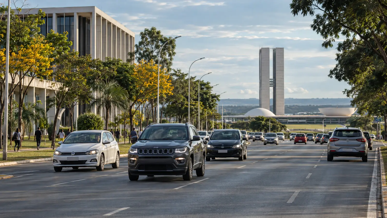 Carros circulam por uma avenida brasileira arborizada.